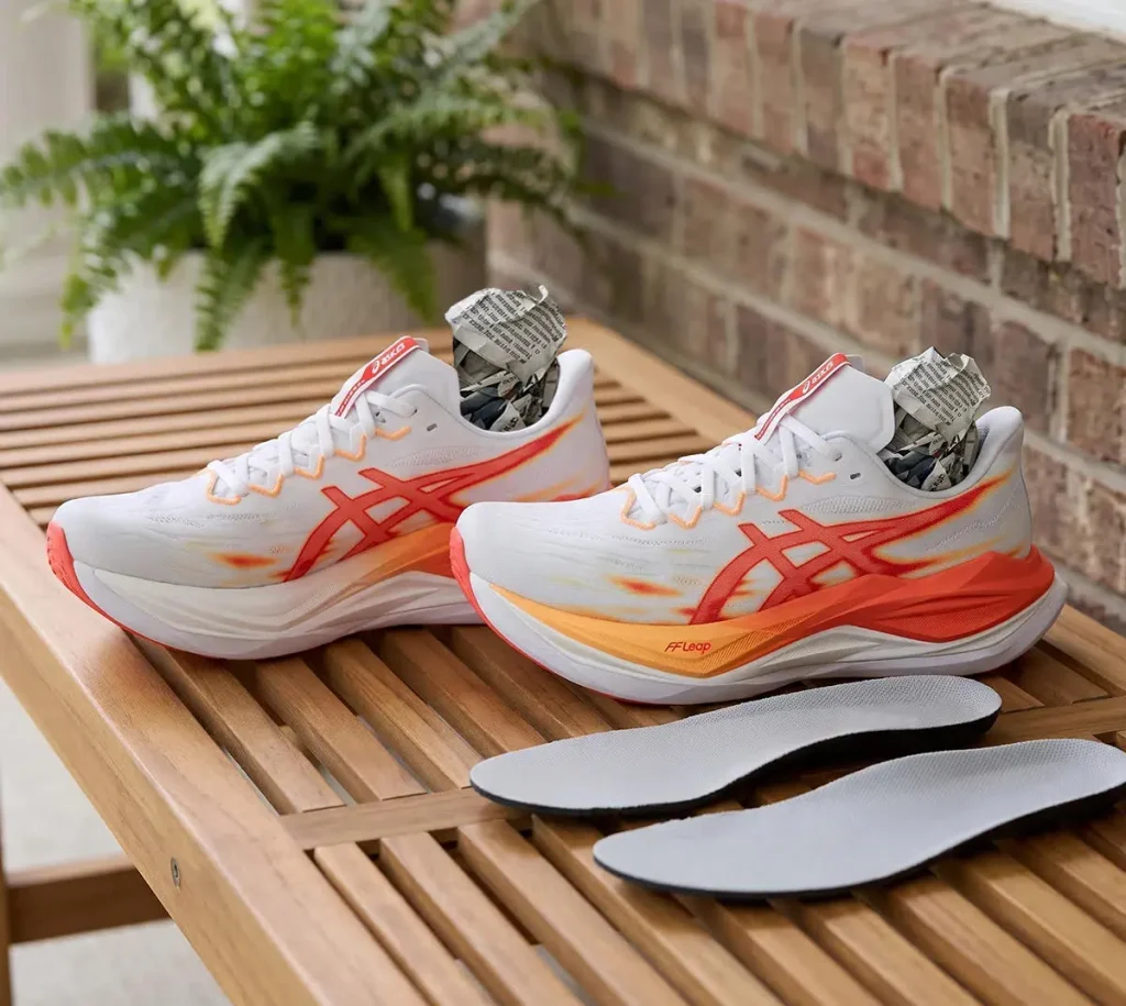 Secado de zapatillas de correr a la sombra con papel absorbente en el interior.